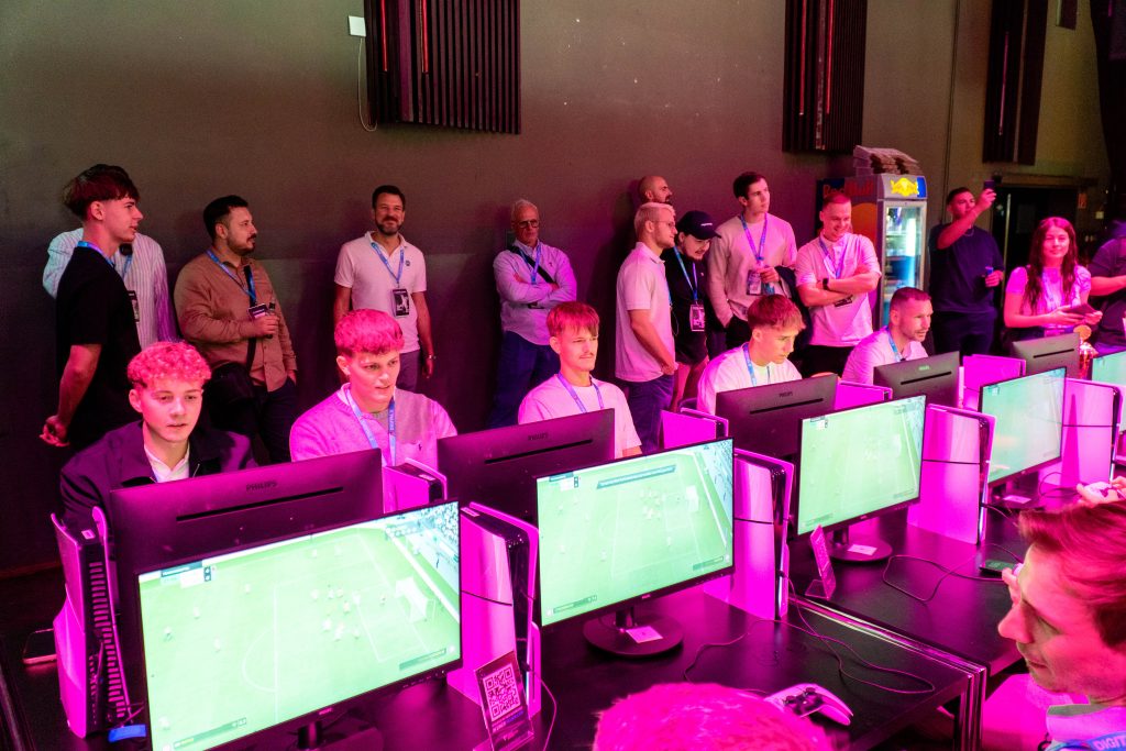 digital-x-2024-93 Konzentrierte Spieler in der ausgelasteten eFußball-Arena auf der Digital X 2024.