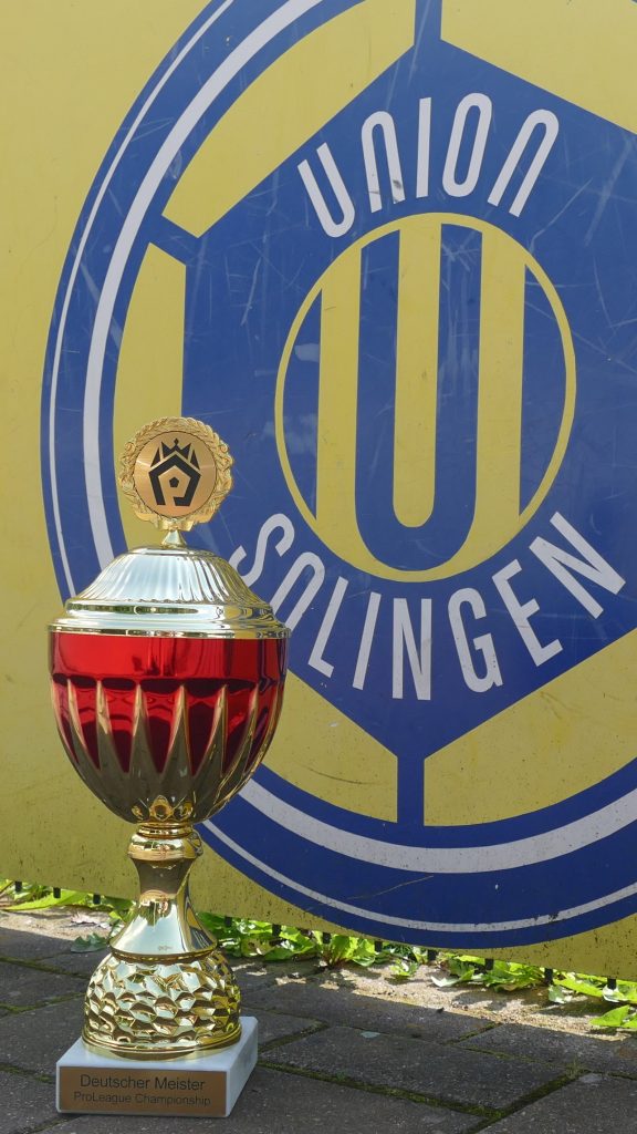 Pokalübergabe-Union-Solingen-Logo Der Meisterpokal vor dem Logo von Union Solingen