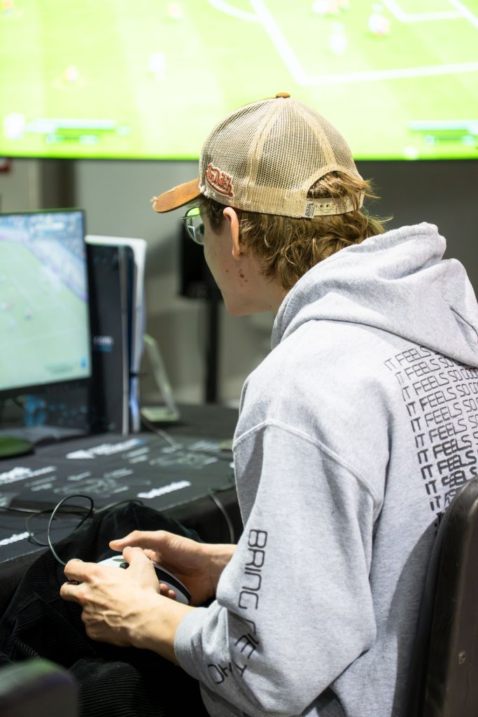 2025-11-27-future-of-festivals-10 Ein konzentrierter Spieler in der eFußball-Arena bei der Future of Festivals 2025.