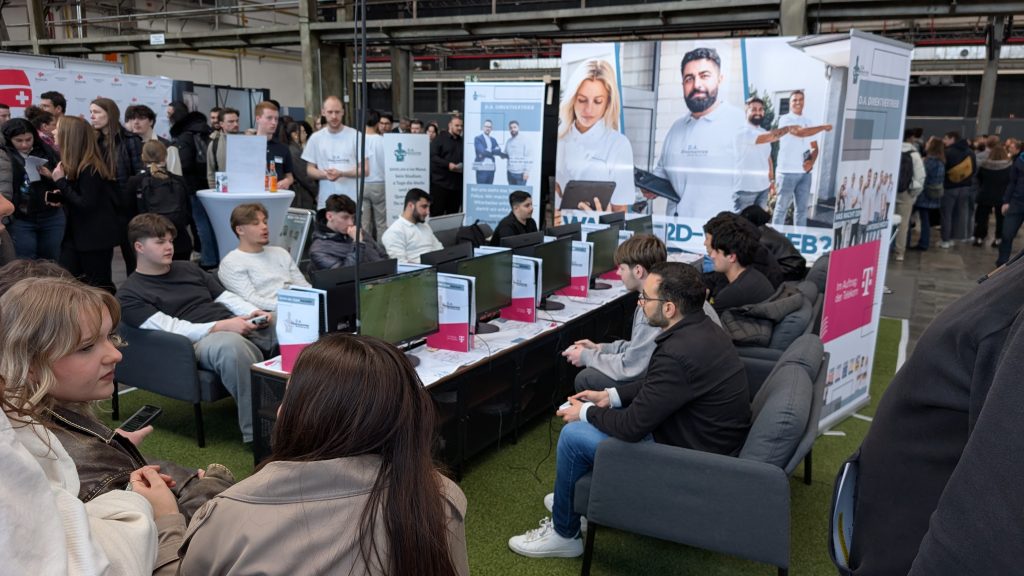 Aktive Spieler vor Zuschauerinnen in der eFußball-Arena bei der Jobmesse in Düsseldorf.