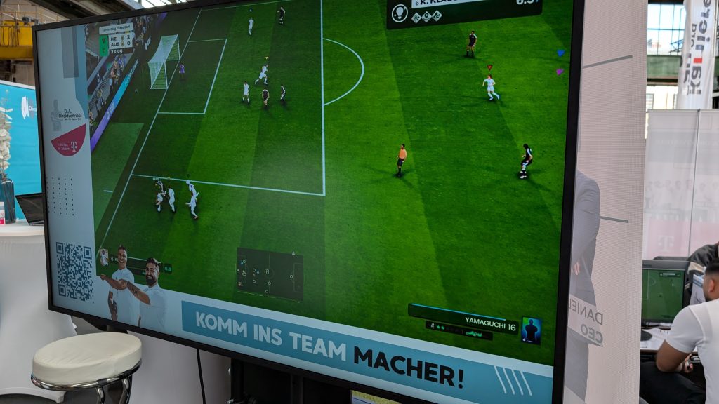 PXL_20260326_131046390.MP Der Gameplay-Bildschirm neben der eFußball-Arena bei der Jobmesse in Düsseldorf.