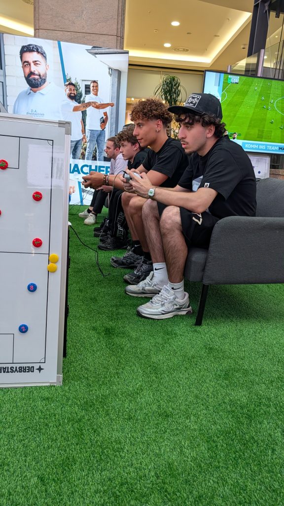 PXL_20260704_175210031.MP Vier Spieler sitzen konuentriert in der eFußball-Arena als Recruiting-Maßnahme für D.A. Direktvertrieb im Centro Oberhausen.