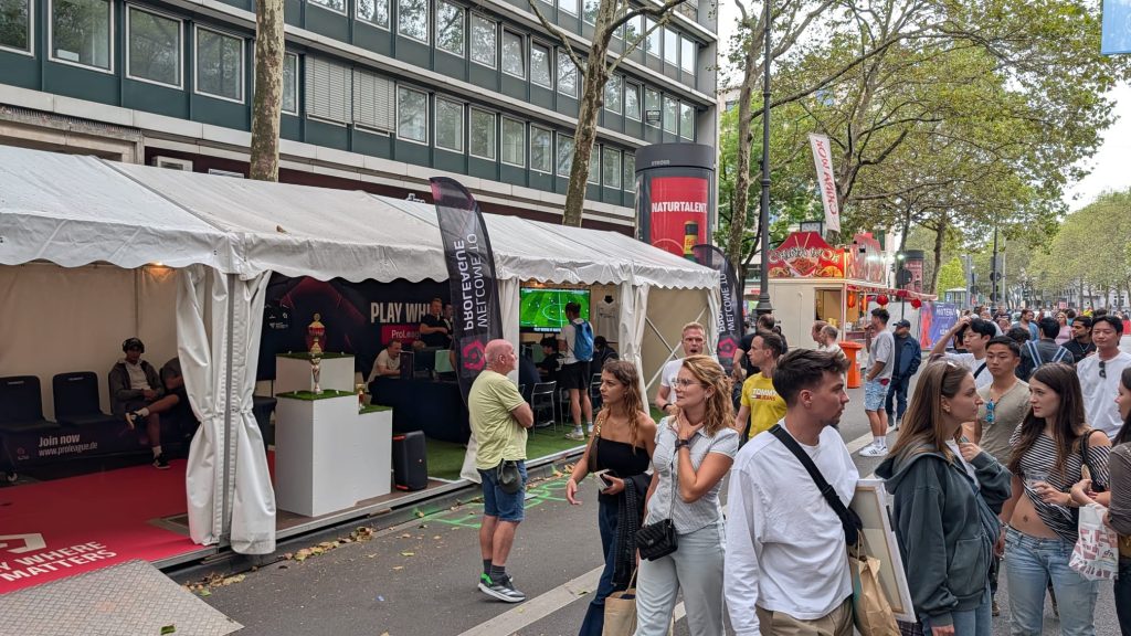 WhatsApp Image 2026-08-29 at 18.03.50 Die voll besetzte eFußball-Arena neben dem Besucherstrom beim gamescom city festival 2026.