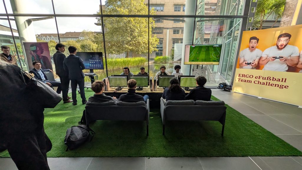 Die Spielenden beim ERGO Campus Day in der eFußball-Arena aus der Zuschauerperspektive auf den Vorplatz.