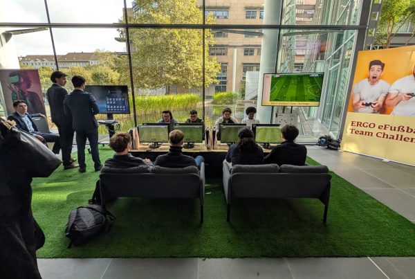 Die Spielenden beim ERGO Campus Day in der eFußball-Arena aus der Zuschauerperspektive auf den Vorplatz.